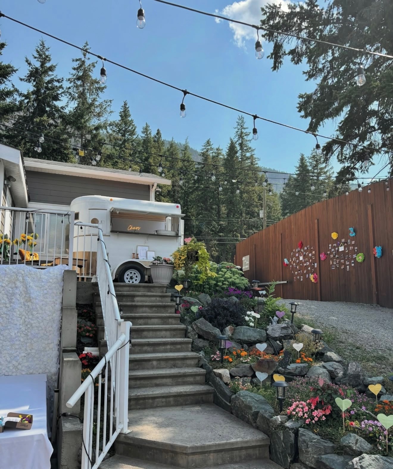 Bar trailer setup with string lights and garden